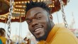 © Alienmarsh - Happy young Black man smiles on a carousel.