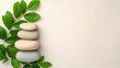 © Butsarakham - A serene arrangement of smooth stones stacked on one another, accompanied by green leaves, creating a tranquil and calming aesthetic.