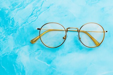 Poster - A minimalist pair of wireframe glasses on a clean marble surface, reflecting ambient light from a nearby window