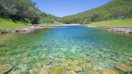 Sticker - Crystal-clear river flowing through lush green valley under a bright blue sky.