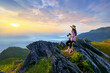 © tawatchai1990 - Traveller sitting on the rock and holding camera take photo at Doi pha mon mountains in Chiang rai, Thailand.