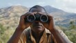 © EFA - A man using binoculars to observe a distant landscape.