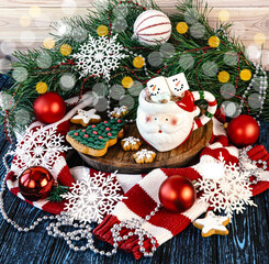 Cup in the form of Santa with marshmallows, Christmas gingerbread Christmas tree, Christmas decorations, Christmas tree branches and a warm sweater. Winter Christmas composition.