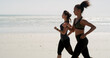 © peopleimages.com - Fitness, women and running on beach for exercise, wellness or cardio training with space. Friends, runners and challenge at ocean for competitive endurance, healthy body or marathon practice in Spain