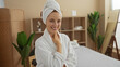 © Krakenimages.com - Woman smiling in a spa setting wearing a bathrobe and towel on head in a relaxing and serene environment