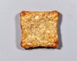© good everyday - A square-shaped, toasted snack or cereal bar with a golden brown texture.