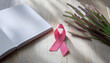 © Matthias - On a light wooden table, a neatly placed pink ribbon is paired with a blank notebook and soft spring blooms. This tranquil setting conveys a sense of calmness and renewal during February