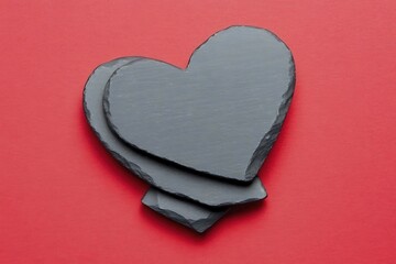 Wall Mural - Three slate hearts on a red background, symbolizing love and affection.