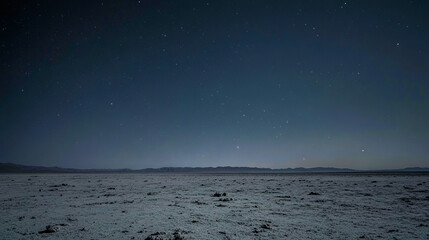 Wall Mural - Starlit night sky over desert landscape with distant mountains