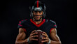 © Evgenii Starkov - A confident male football player in black and red uniform holding a football, ready to lead his team under intense lighting.