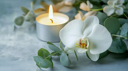 Tranquil white orchid and candle arrangement with eucalyptus leaves