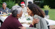 © peopleimages.com - Christmas, dinner and women with laughing by home for bonding, festive celebration and social gathering. Happy family, people and funny conversation on patio with food, holiday lunch and relationship