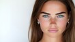 © Santri - Close-up portrait of a young woman with blue eyes and freckles.