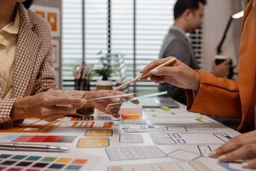 Wall Mural - ux developer and ui designer brainstorming about mobile app interface wireframe design in the office