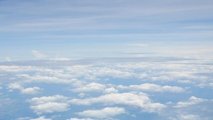 Wall Mural - view from plane over blue sky with white Fluffy clouds while flying through in sunny summer time.nature blue sky cloud and sun for Clean Environment, save energy or transportation holiday concept. 
