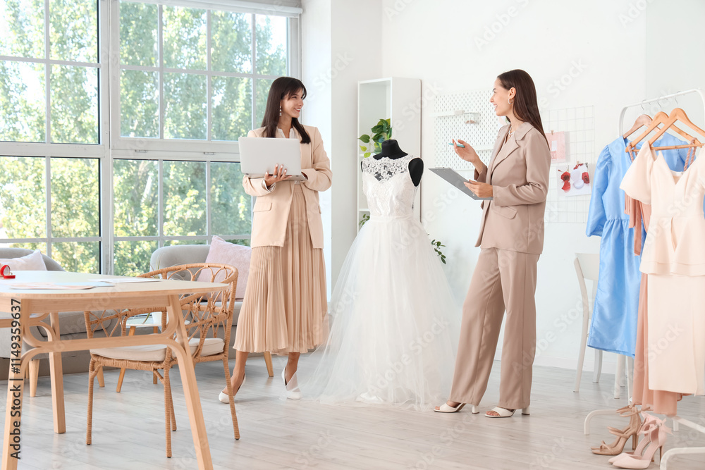 Female wedding planners with dress working in office