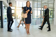 © ArcursCoop/peopleimages.com - Business people, walking and portrait of woman in office for productivity, synergy and coworking. Professional, corporate and men and women in busy workplace for movement, rush and hurry in lobby