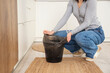 © Pixel-Shot - Woman replacing garbage bag in trash bin at home