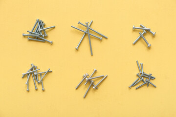 Wall Mural - Piles of different tap bolts on yellow background