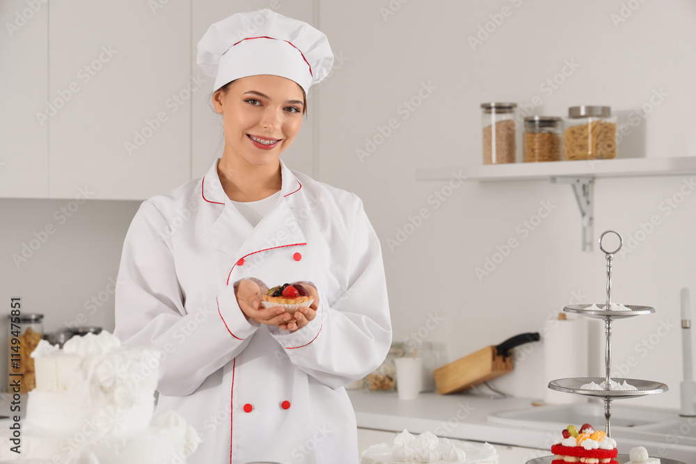 Female confectioner with cake in kitchen