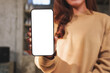 © Farknot Architect - Mockup image of a woman holding and showing mobile phone with blank white screen