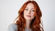 © michaswelt - Closeup of happy attractive young woman with long wavy red hair and freckles wears stylish t shirt looks happy and smiling isolated over white background