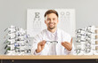 © Studio Romantic - Portrait of a ophthalmologist holding a pair of eyeglasses in a clinic office. Doctor highlights of eye care, emphasizing professional healthcare and the role of eyewear in maintaining health.
