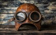 © Itsaree  - Antique leather aviator helmet and goggles placed on a rustic wooden surface, nostalgic and adventurous vibe, perfect for retrothemed decor, vivid details