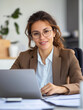 © Leopoldine - Portrait d'une travailleuse de bureau : femme en tenue professionnelle assise devant un ordinateur, assistante de direction, chef de projet, cadre administratif, juriste, RH au travail