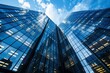 © juliars - Glass skyscrapers rising towards a blue sky with some clouds, symbolizing modern business and urban development