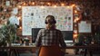 © afif - Programmer working at desk with large monitor, headphones, and mood board.