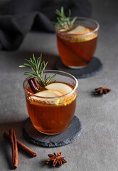 Wall Mural - Homemade apple punch with fresh apples, cinnamon and rosemary in a two cups on a dark background