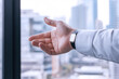 © Ari - A hand is reaching forward to shake hands or support, office environment