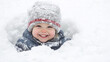 © pattozher - Snowy Day Delight: A little girl with a beaming smile, bundled up in winter attire, playfully peeks out from a snowy mound. The image radiates pure joy and innocent wonder.