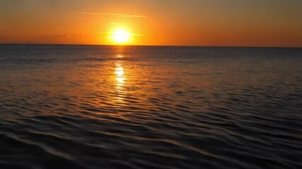 Wall Mural - breathtaking sunset over calm ocean waters with golden reflections illuminating the horizon and crea