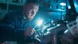© Roey - Mechanic in workshop inspecting car engine with flashlight, focusing on engine details, well-litgarage with tools and parts scattered around