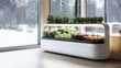 © azi - Indoor smart garden with herbs, vegetables, and fruits growing under LED lights, near a large window with a snowy winter landscape view.