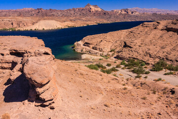 Wall Mural - A rocky desert landscape with a body of water in the distance