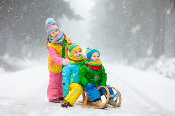 Wall Mural - Kids play in snow in winter park