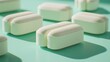 © arsyi_06 - Close-up of multiple oblong white pills arranged on a mint green surface, displaying a textured surface and gentle shadows.