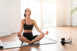 © Prostock-studio - Morning Yoga Routine Concept. Peaceful sporty woman sitting in padmasana lotus pose on floor mat by window in minimal living room interior, doing breathing exercise with closed eyes, free copy space