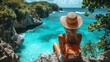 © Wiryo - Woman traveler sits on a cliff overlooking a tropical ocean.