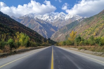 Wall Mural - Explore a scenic mountain road flanked by lush forests and snow capped peaks in autumn colors