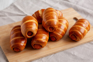 Wall Mural - Homemade Sausage Buns on a bamboo board, side view.