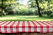 © Muhammad - Red checkered tablecloth on wooden table, blurred park background.
