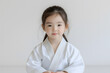 © Lelik - A young girl sitting in a martial arts uniform, radiating calm focus and dedication to her practice