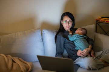 Canvas Print - Mother multitasking with baby and laptop late night