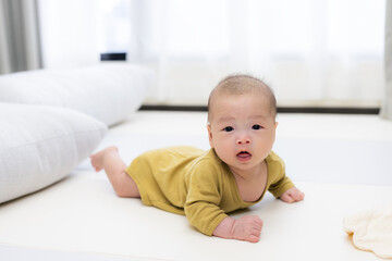 Wall Mural - Baby exploring and lying on soft play mat at home