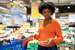© Westend61 - Woman buying cherry tomatoes in grocery store at mall
