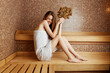 © SHOTPRIME STUDIO - Relaxing in the sauna woman holding plant on wooden bench in steam room
